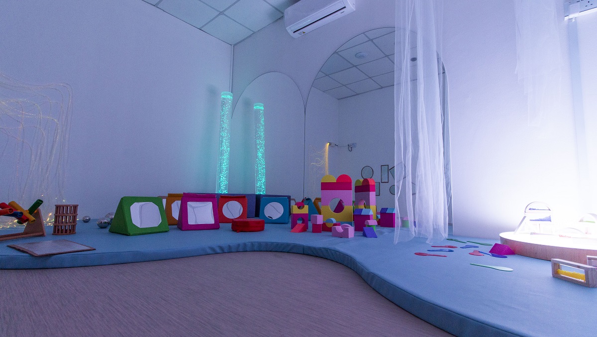 Infant sensory room with soft mats, play materials, and calming sensory elements